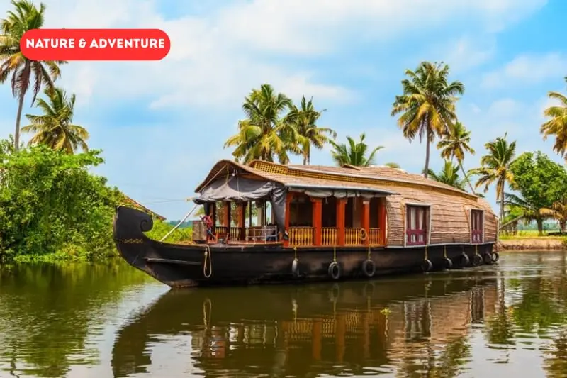 Forested lake surrounded by wooded hills, similar to the Periyar reserve